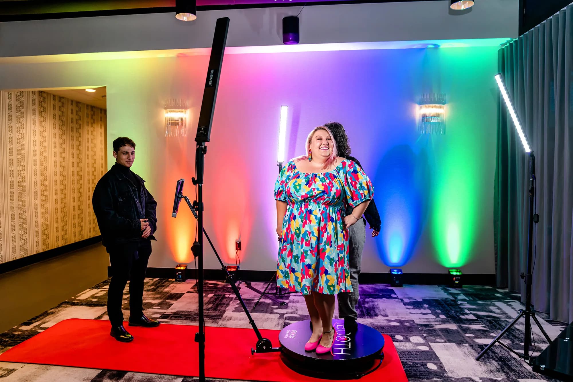 Guest on a 360 photo booth platform with LED lighting and red carpet at an Orlando event