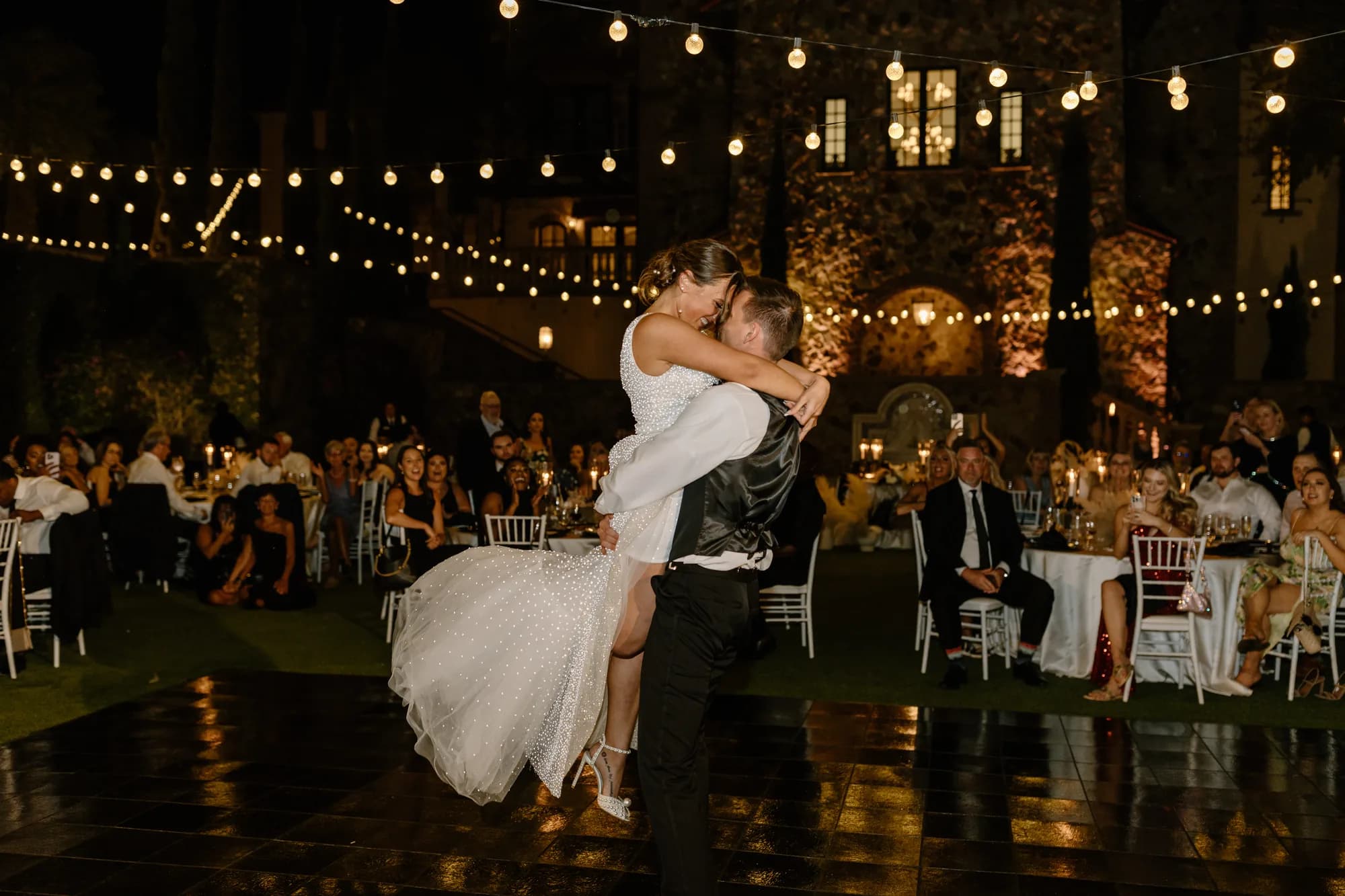 Bride and groom sharing their first dance under bistro lighting at an Orlando wedding reception with iRock Your Party